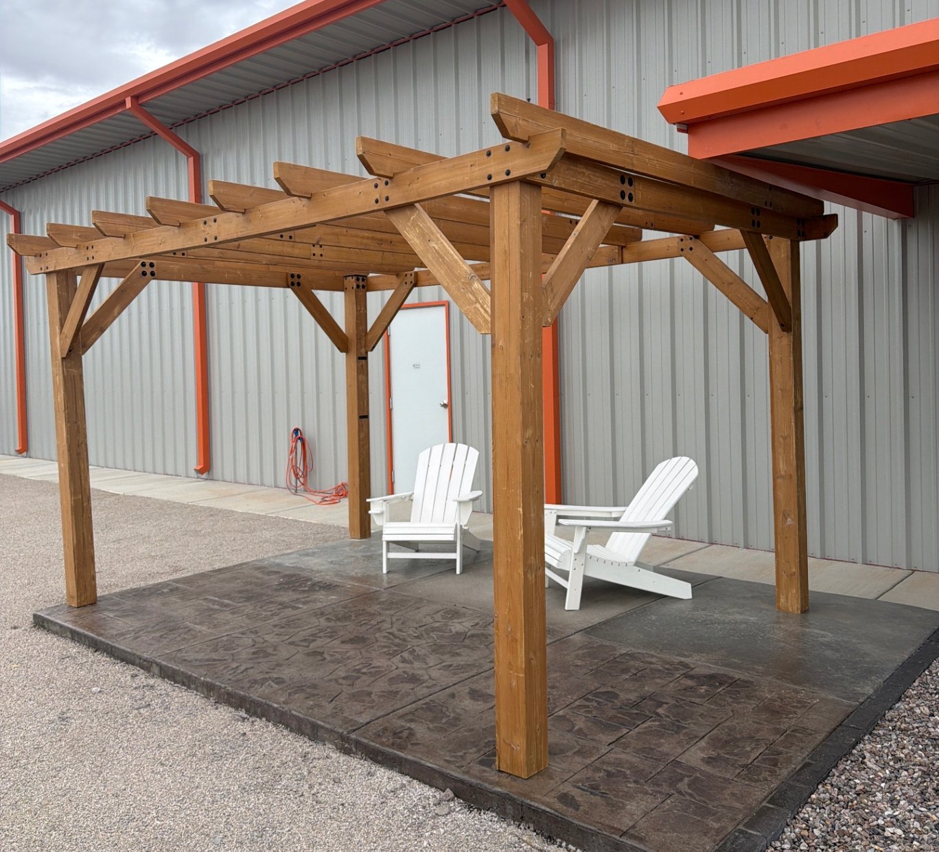 Stamped concrete patio under a cedar pergola at the EquipScape yard in El Paso, built with pavers and base material from our yard